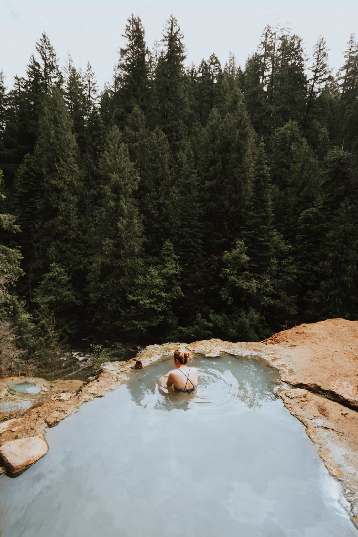 Emily Mandagie sitting in Umpqua Hot Springs