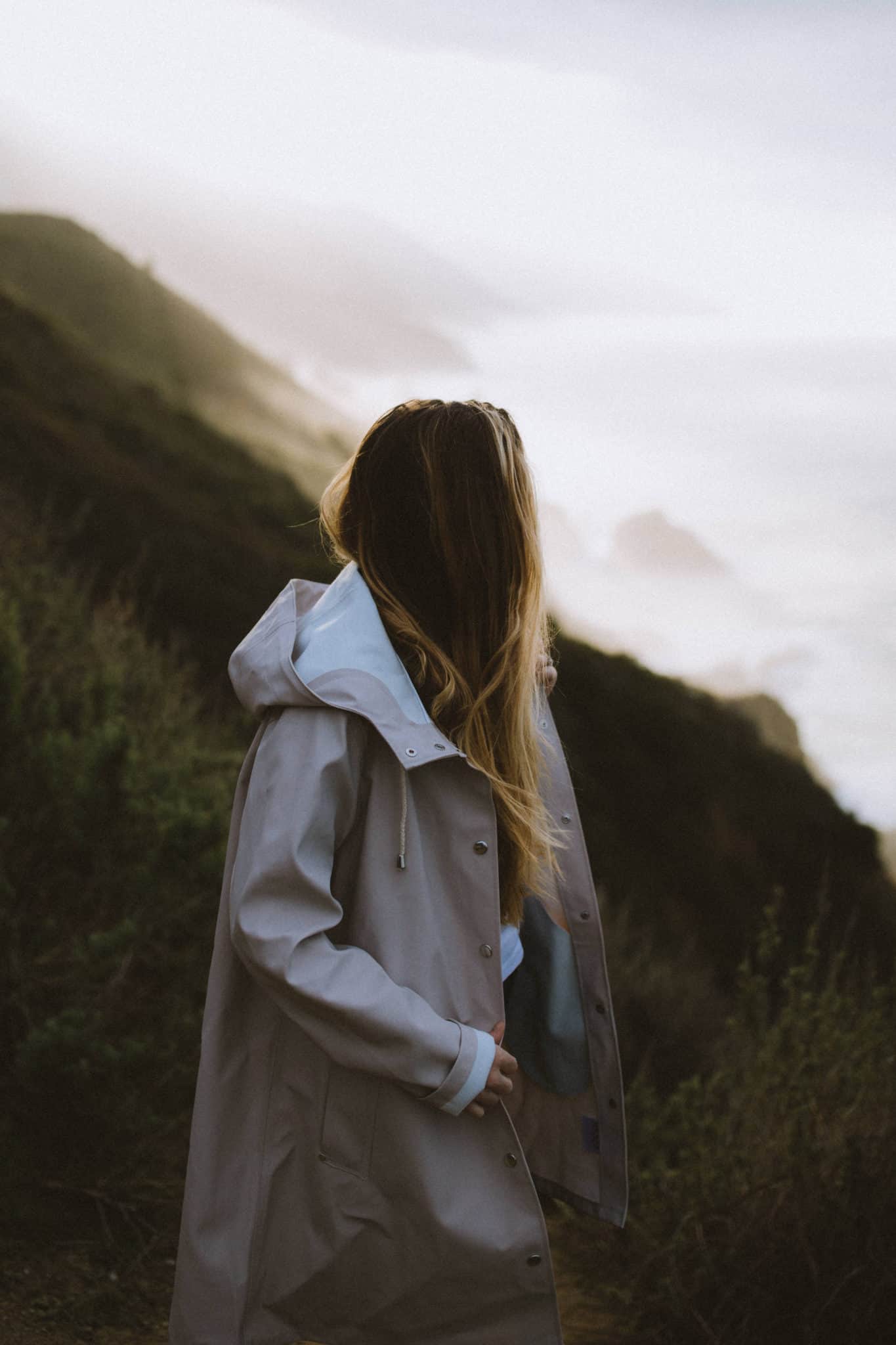 woman wearing stutterheim light sand rain jacket at Big Sur California Coast