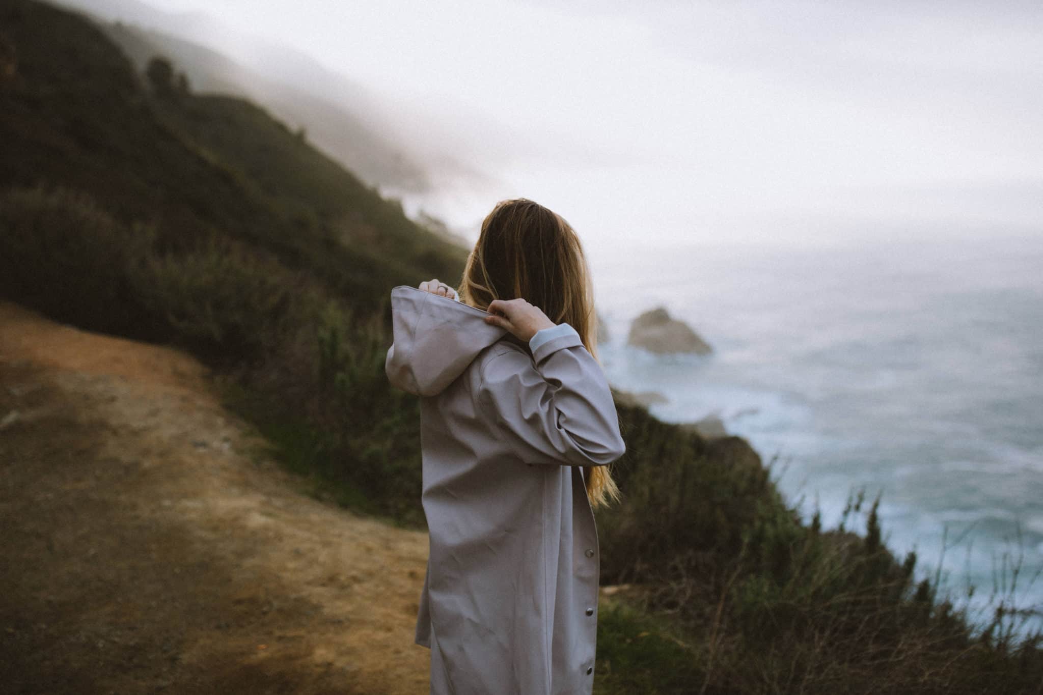 woman wearing stutterheim light sand rain jacket at Big Sur California Coast