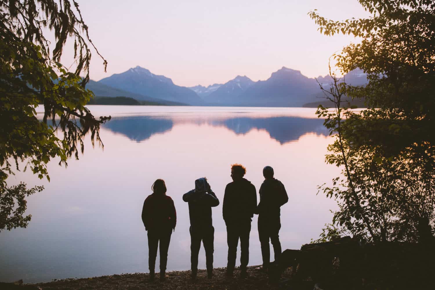 people gathered around lake at dusk