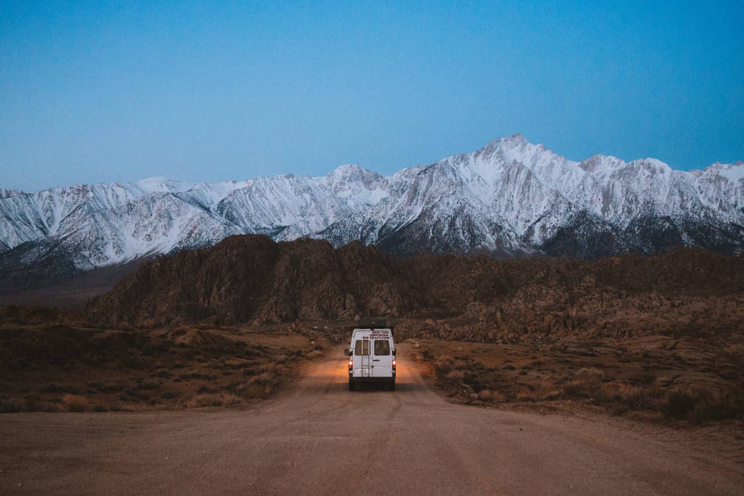 Van driving on Alabama Hills before sunrise