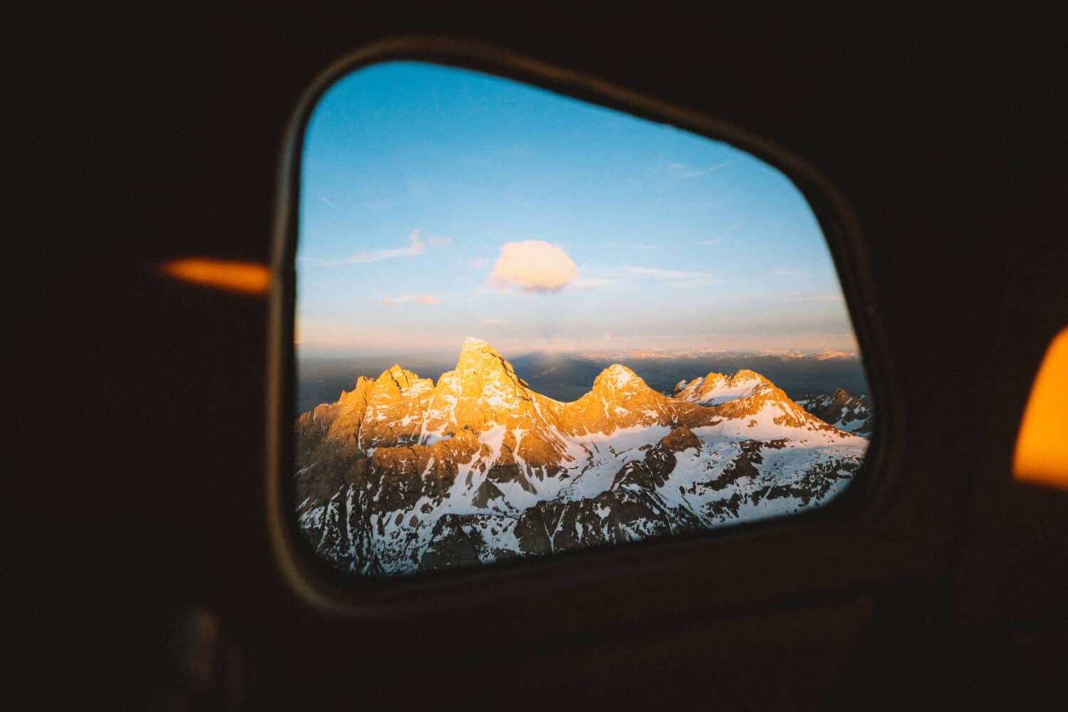 View of the Grand Tetons from plane window - TheMandagies.com