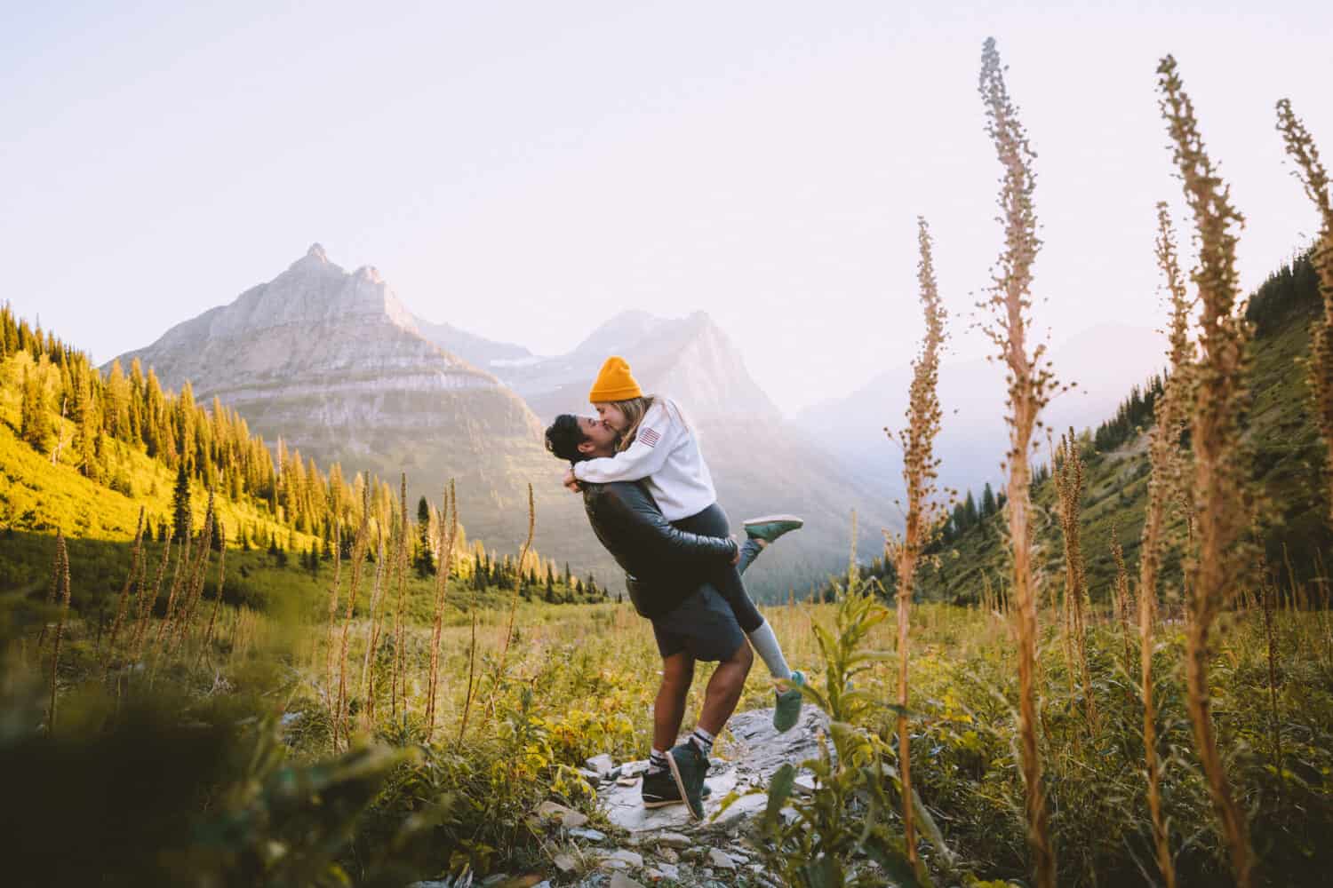 Berty and Emily Mandagie kissing in Glacier National Park