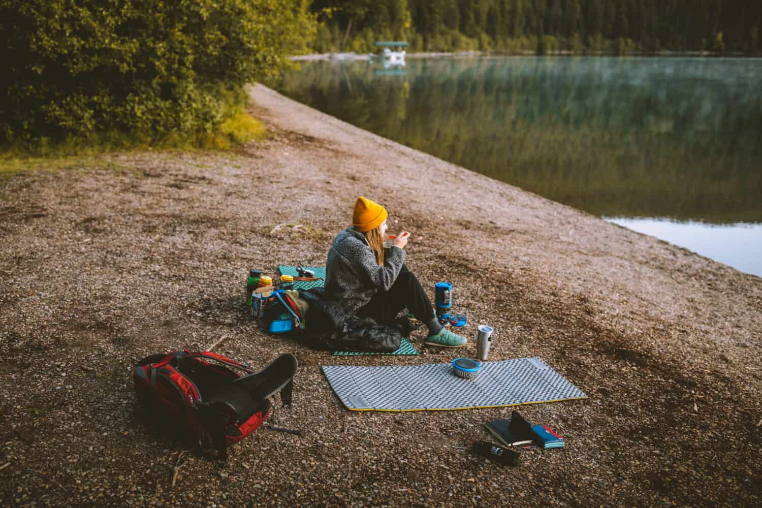 Emily eating breakfast on shores of Bowman Lake Glacier National Park