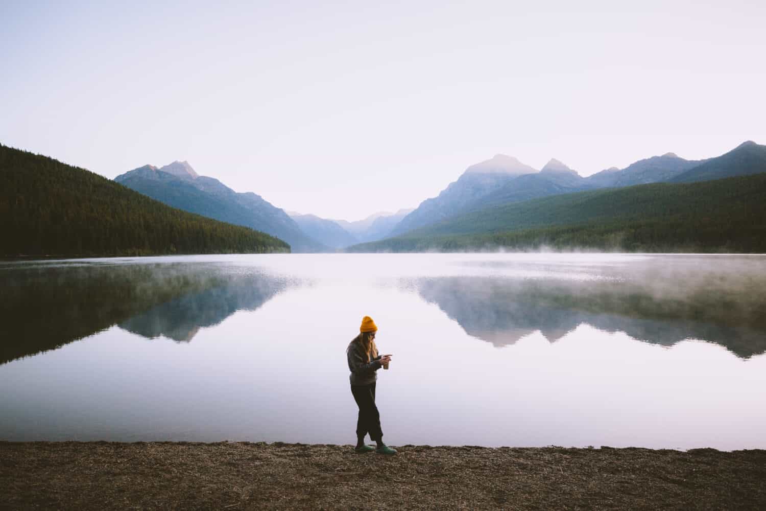 Emily drinking coffee on shores of Bowman Lake