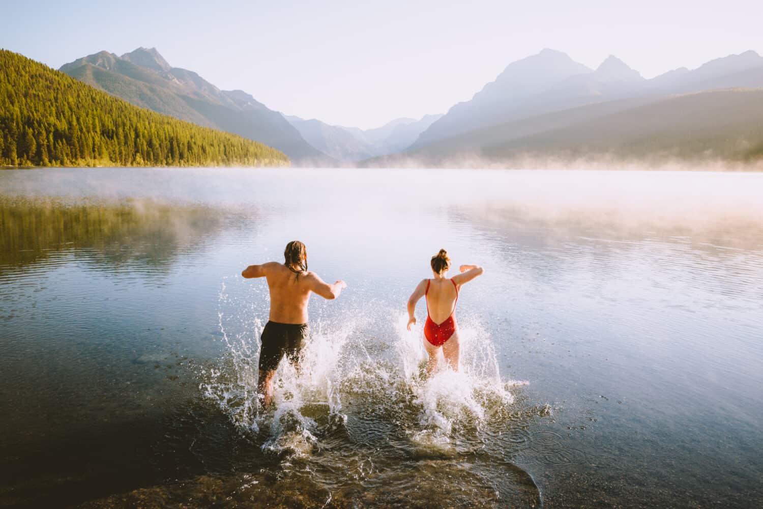 Emily and Joseph jumping into Bowman Lake, Glacier