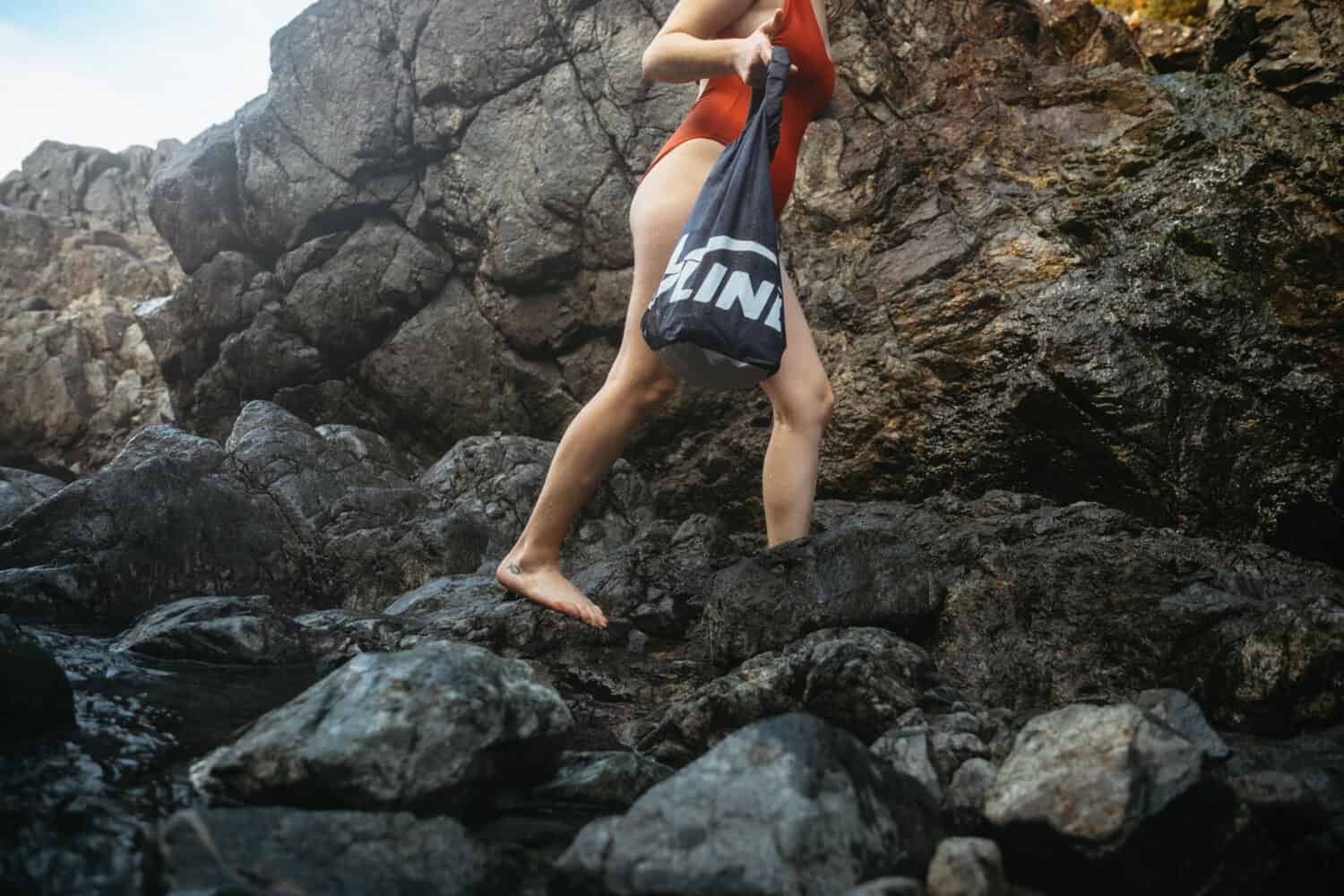 Emily Mandagie carrying dry bag in hidden hot springs BC - THeMandagies.com