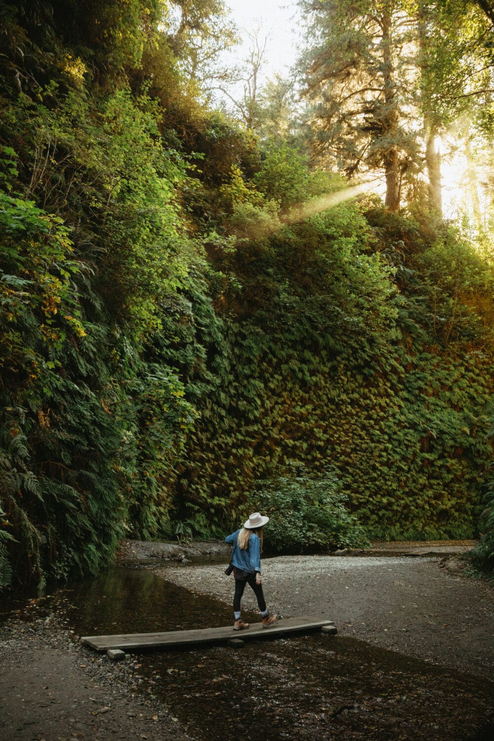 Emily Mandagie crossing a creek on Fern Canyon Trail - California