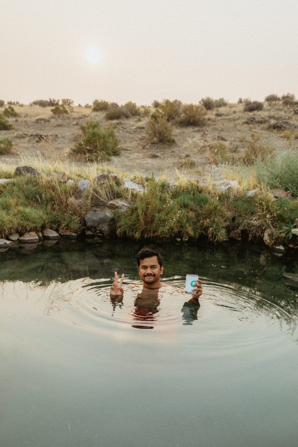 Berty Mandagie sitting in Willow Creek Hot Springs