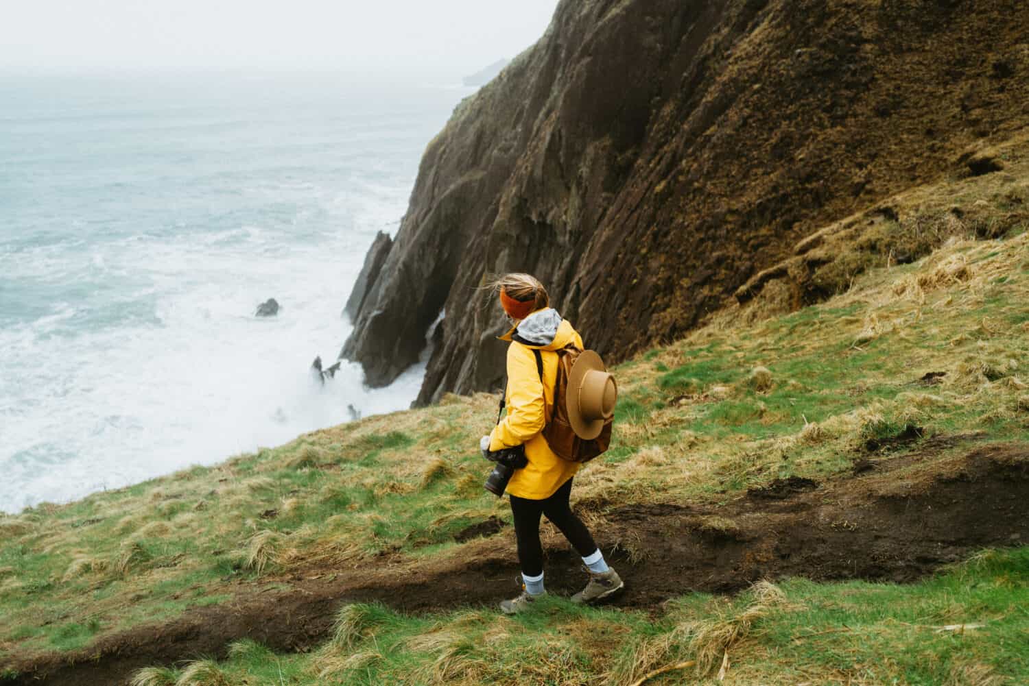 Emily Mandagie walking on Elk Flats Trail near the cliffside on the Oregon Coast