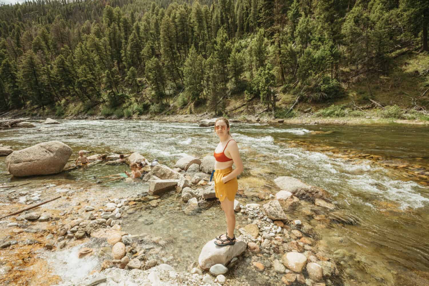 Emily Mandagie sitting next to riverside pools on Salmon River