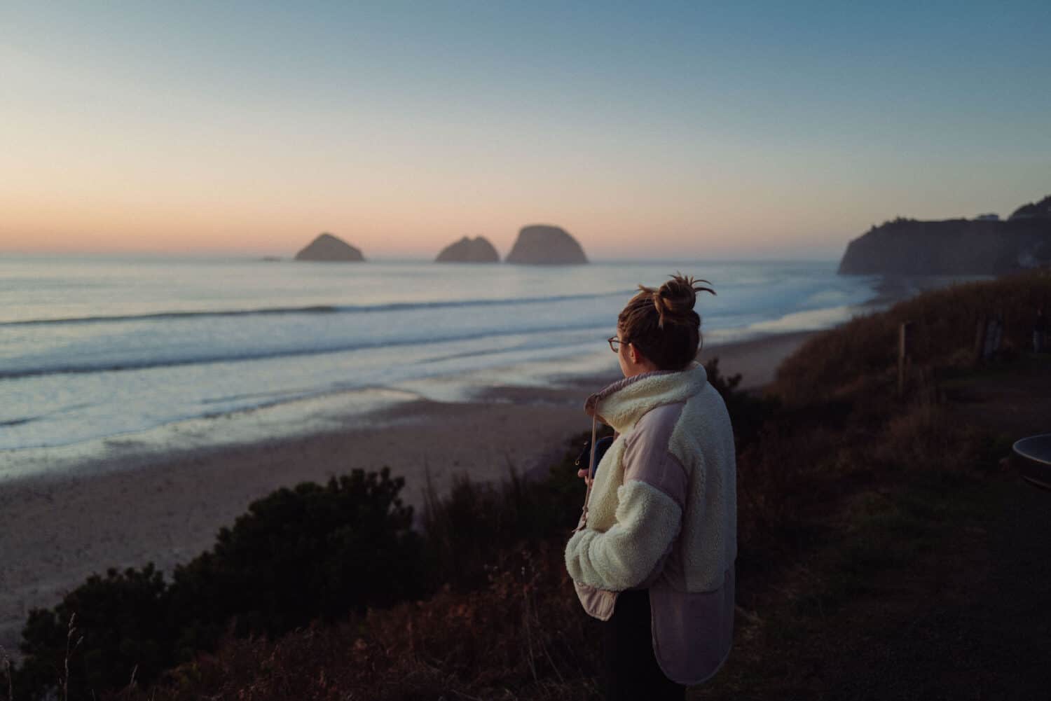 November Outdoor Holidays - Emily Mandagie watching the sunset in Oceanside, Oregon