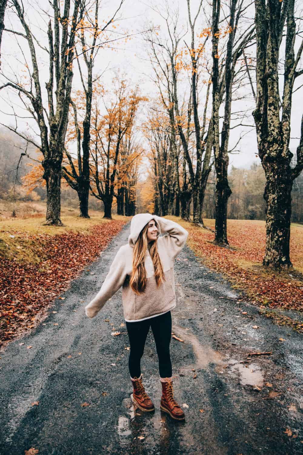 October Outdoor Holidays - Emily Mandagie walking through autumn leaves