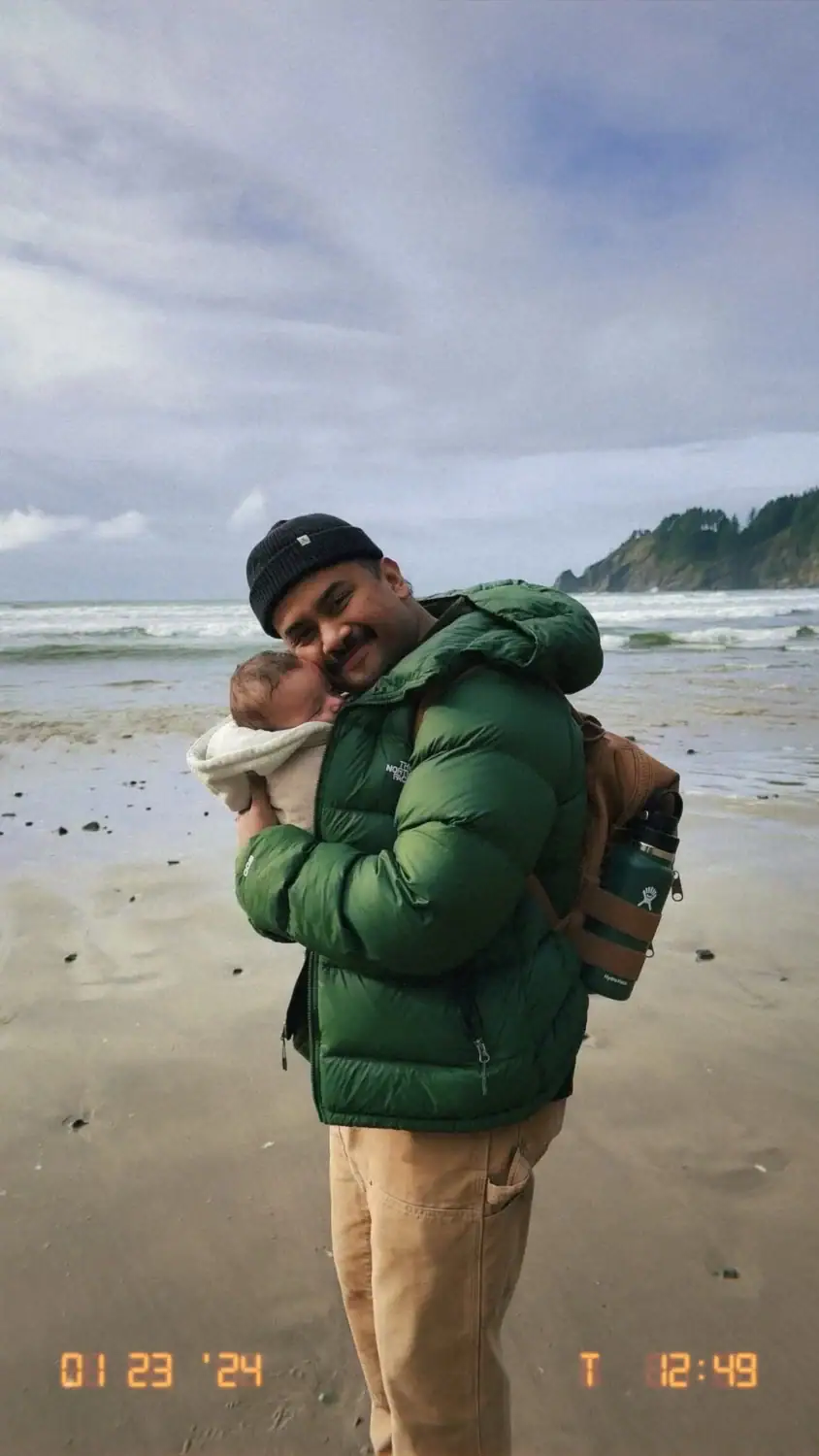 Berty Mandagie holding a 7 week old baby on the Oregon Coast